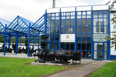 Gebäude des Deutschen Pumpen-Museums mit verschiedenen Pumpen im Außenbereich